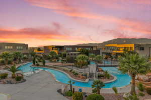 Pool at dusk featuring a patio area and a community pool