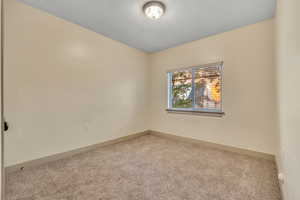 Carpeted spare room with baseboards