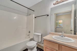 Full bath with vanity, tub / shower combination, and dark tile patterned floors