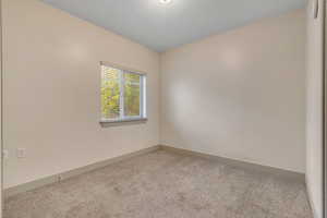 Carpeted spare room with baseboards