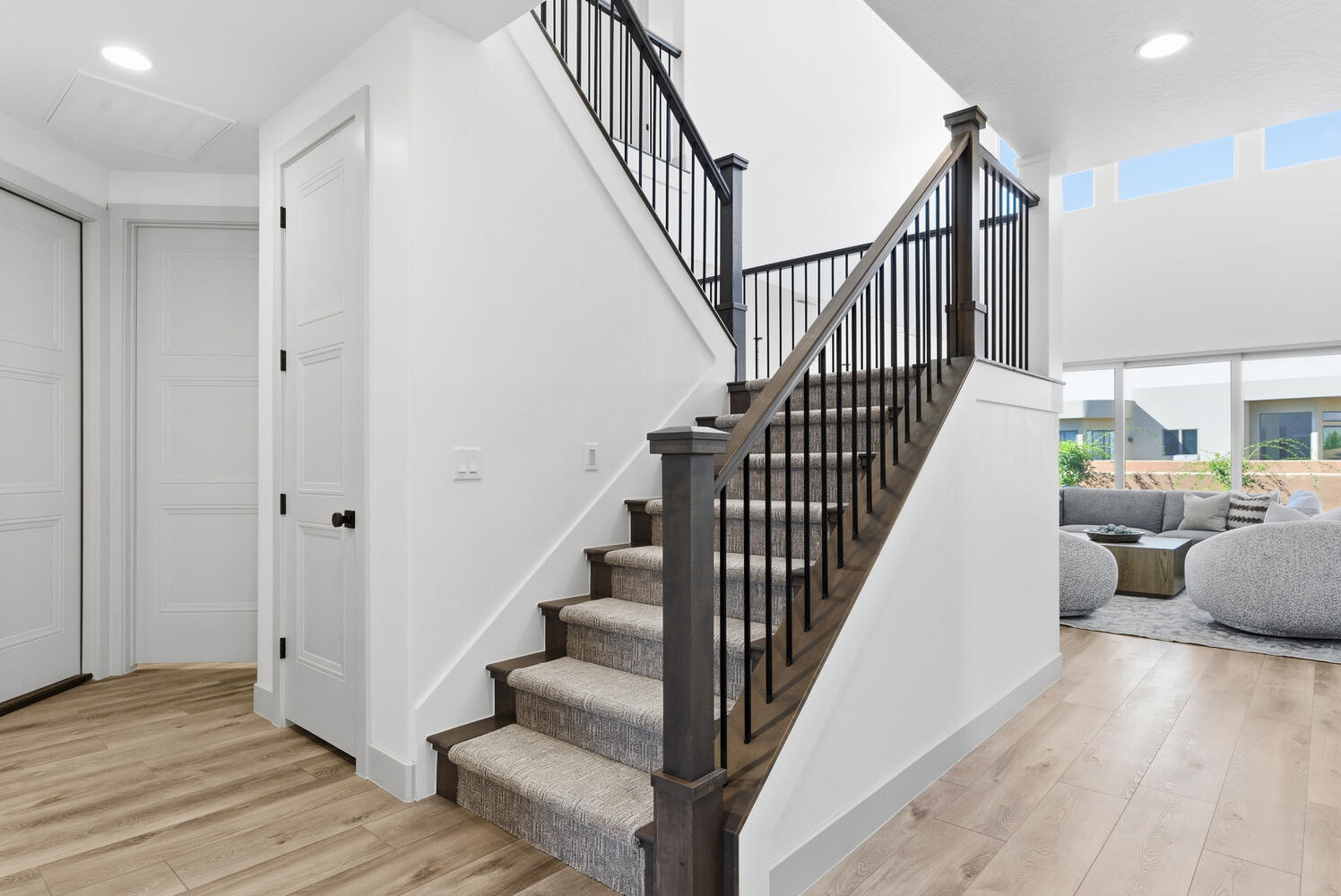 Stairs featuring recessed lighting, healthy amount of natural light, wood finished floors, and a high ceiling