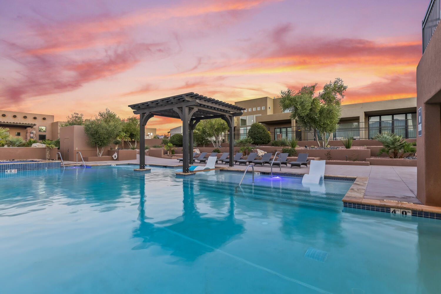 Pool at dusk featuring a community pool and a pergola