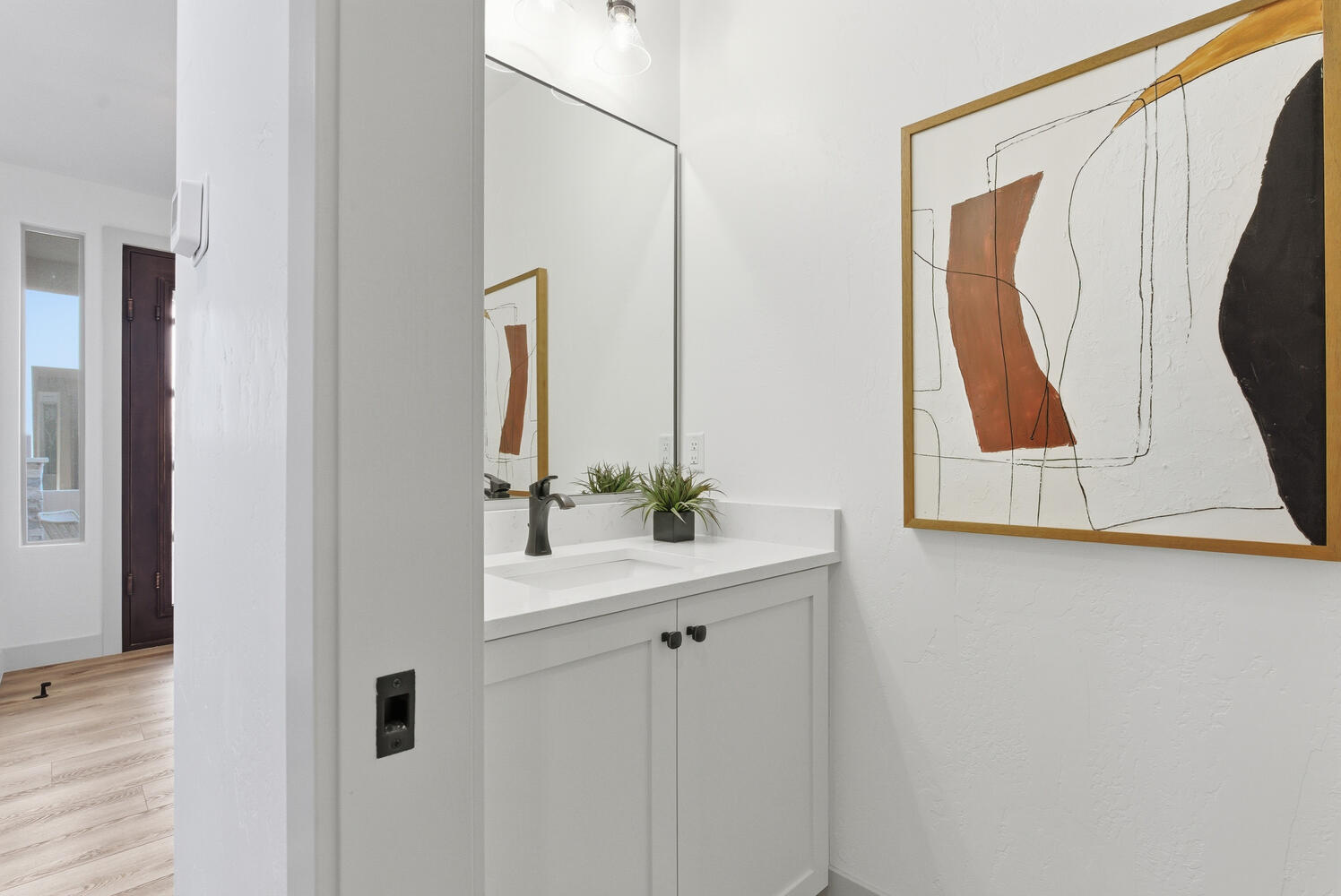 Half bath with vanity and light wood finished floors