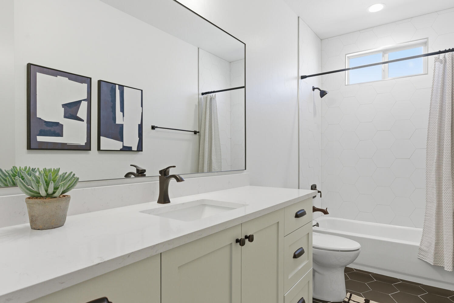 Bathroom featuring vanity, shower / bath combo with shower curtain, and dark tile patterned floors