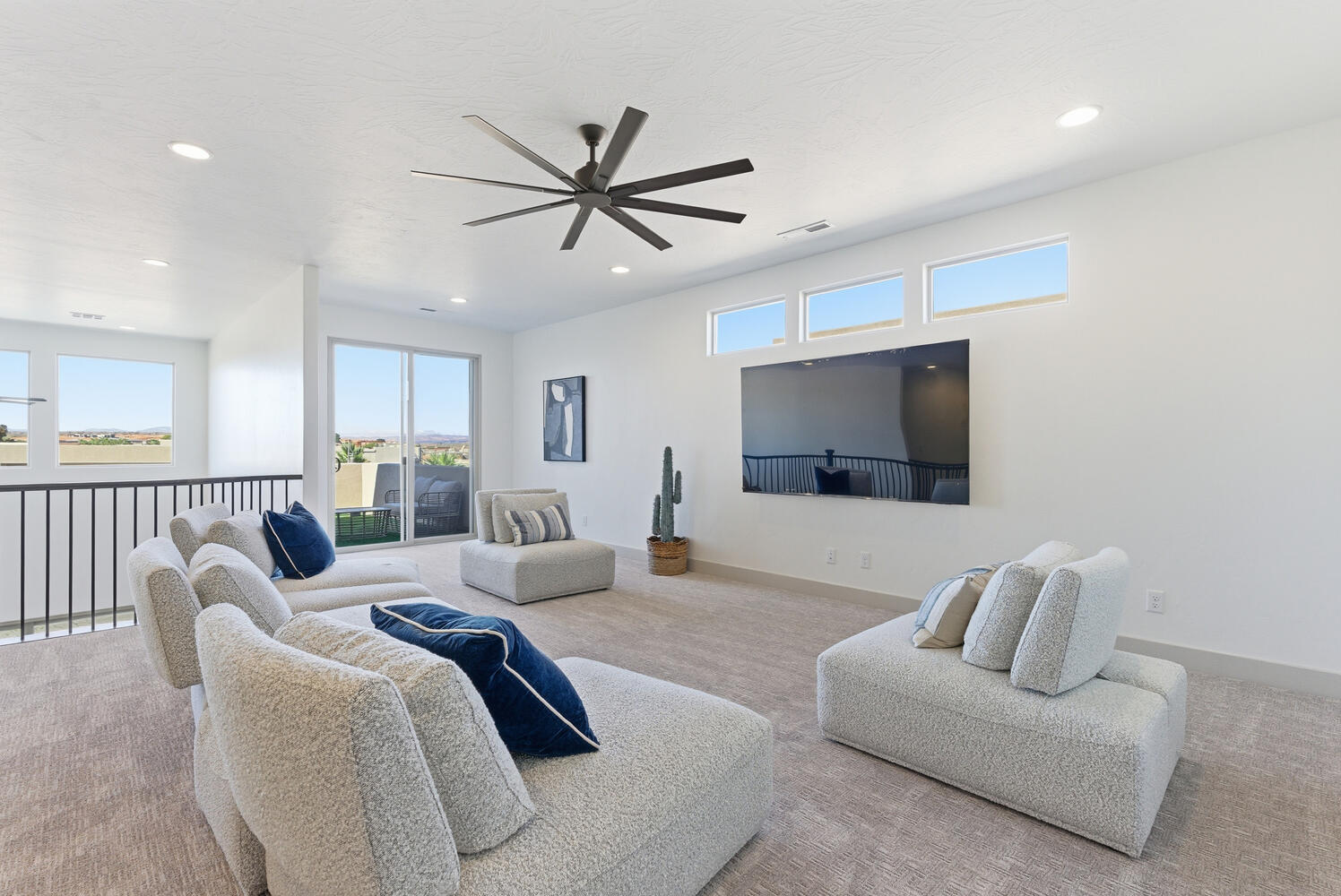Carpeted living area featuring a ceiling fan and recessed lighting