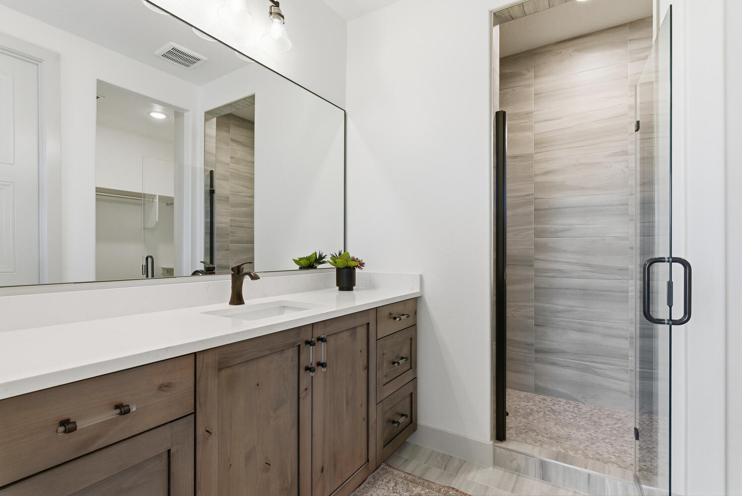 Full bath featuring vanity, a stall shower, a spacious closet, and recessed lighting