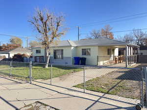 View of front of property with a fenced front yard, a gate, and covered porch