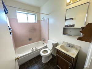 Full bathroom featuring shower / bathtub combination, vanity, and dark tile patterned flooring