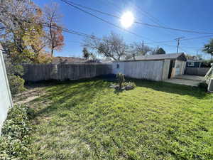 Fenced backyard with an outbuilding