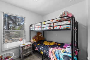 Bedroom featuring dark colored carpet and a textured ceiling