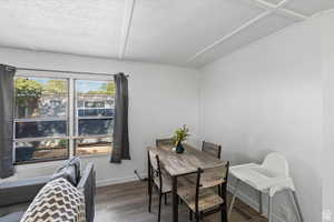 Dining room with wood finished floors and a textured ceiling