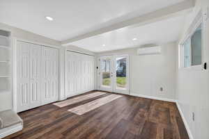 Unfurnished bedroom featuring french doors, access to exterior, two closets, dark wood-style floors, and recessed lighting
