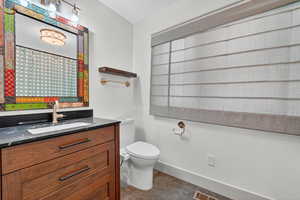 Full bath featuring vanity, a shower with shower curtain, and dark tile patterned flooring