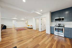 Basement apartment kitchen with stainless steel appliances, light countertops, recessed lighting, and gray cabinetry