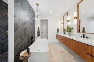 Primary en suite, soaking tub, tile walls and floors, chandelier and walk-through shower