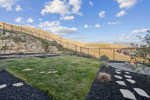 Fenced backyard featuring a fire pit and a mountain view