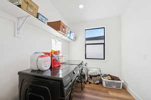Washroom with wood finished floors, washer and dryer, and recessed lighting