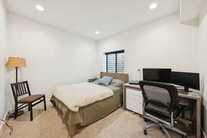 Basement bedroom, #6/8, with light carpet, a desk, and recessed lighting