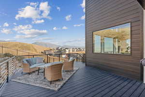 Wood-style deck off kitchen featuring a mountain view