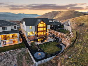 Back of house at dusk with a patio, a fenced backyard, a mountain view, and a gas fire pit