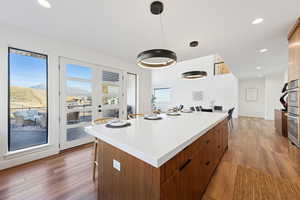 Spacious kitchen island with modern wood cabinetry, and mountain view