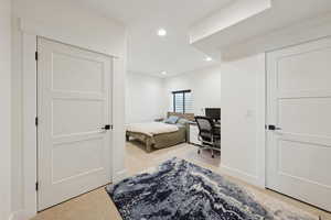 Basement bedroom, #6/8, with light carpet, a desk, and recessed lighting
