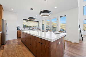 Spacious kitchen island with modern wood cabinetry, and mountain view