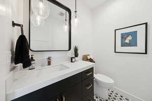 Half bathroom featuring vanity and tile flooring