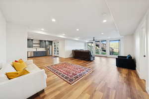 Basement apartment great room with french doors, recessed lighting, and light wood-style floors