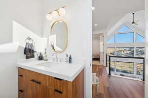 Ensuite bathroom with vanity, dark wood-style flooring, recessed lighting, a ceiling fan, and high vaulted ceiling