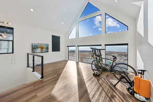 Workout room with high vaulted ceiling, large windows, and mountain view