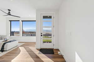 Doorway to outside with a mountain view, wood finished floors, recessed lighting, and ceiling fan