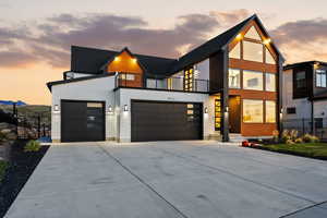 Modern home featuring large driveway and a 3-car garage