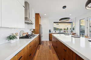 Kitchen with modern cabinets, spacious island, gas range, and range hood