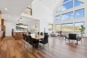 Great room with light wood-style flooring, high vaulted ceiling, and recessed lighting