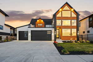 Modern home featuring large upper deck, expansive windows, and 3-car garage
