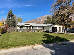 Ranch-style house featuring a mountain view, a chimney, brick siding, a garage, and driveway