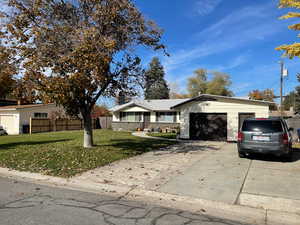Ranch-style home featuring concrete driveway and an attached garage