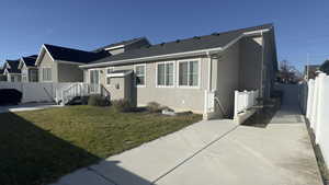 View of front facade featuring a fenced backyard and stucco siding