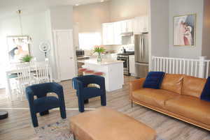 Living area with light wood-type flooring and a towering ceiling