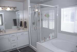 Bathroom with double vanity, a stall shower, a garden tub, and ensuite bathroom