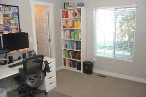 Office space featuring light colored carpet and baseboards