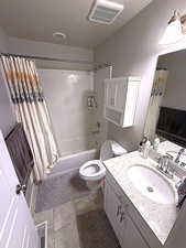 Bathroom featuring vanity, shower / bath combination with curtain, tile patterned floors, and a textured ceiling
