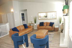 Living room featuring wood finished floors and vaulted ceiling