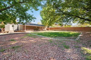 Rear view of house with a fenced backyard and covered porch
