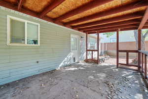 Unfurnished sunroom featuring a patio area and beamed ceiling