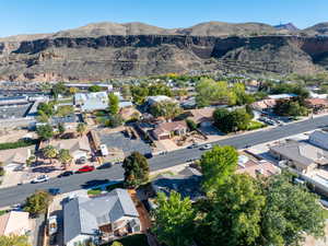 Aerial view of property and surrounding area featuring a mountain backdrop and nearby suburban area