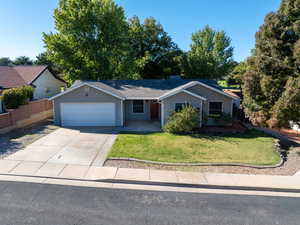 Ranch-style house featuring concrete driveway, an attached garage, and roof with shingles