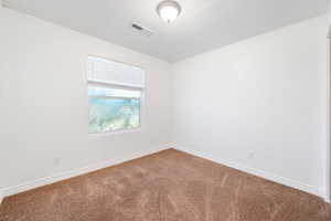 Spare room featuring carpet floors and baseboards