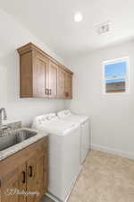 Washroom with washing machine and clothes dryer, cabinet space, and recessed lighting